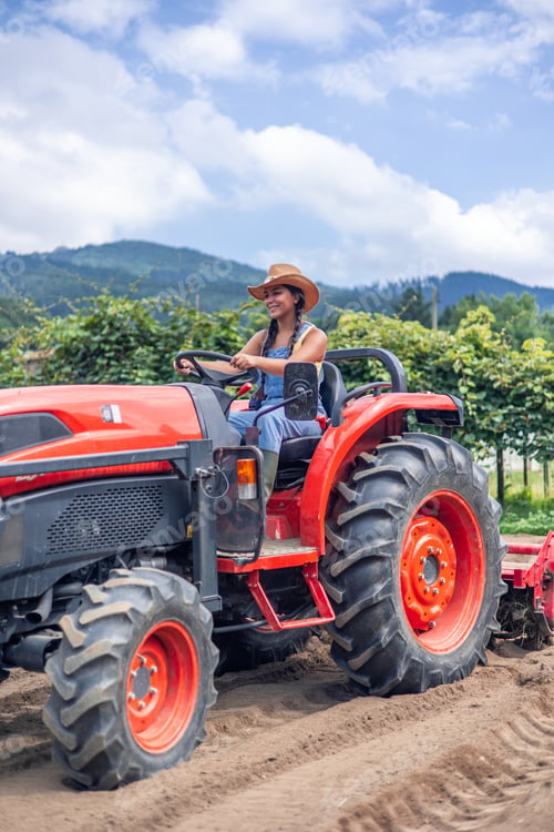 Preview: vertical Latin farmer woman driving tractor plowing field in farm