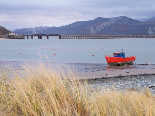 Preview: Old fishing boat and Barmouth Bridge in Barmouth Harbour with Cader (Cadair) mountains behind (part