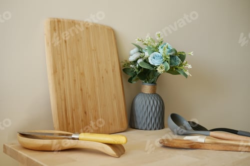 Preview: Wooden Cutting Board with Cooking Utensils and Vase of Flowers on Kitchen Counter