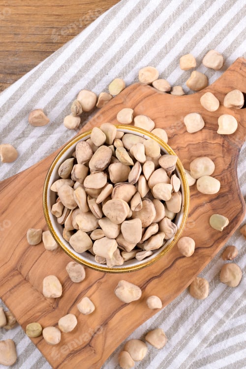 Preview: Cicerchia or indian pea on a ceramic bowl with napkin on natural wooden background, gluten free food