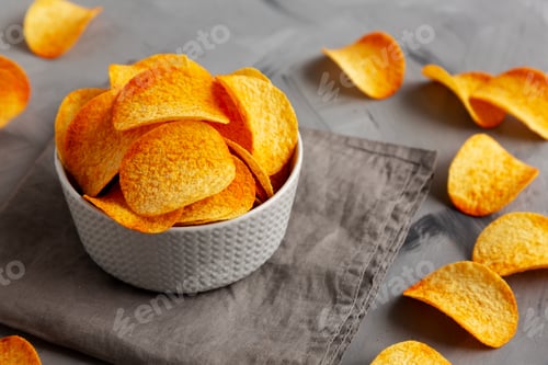 Preview: Unhealthy Paprika Flavoured Potato Chips in a Bowl, side view.