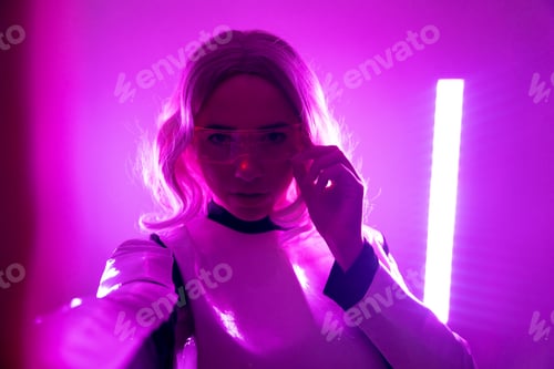 Preview: Woman in futuristic suit and glasses with pink led lights, virtual concept, metaverse, selfie