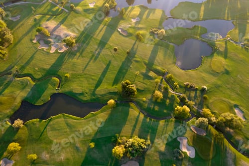 Preview: Aerial view of a green golf course at sunset