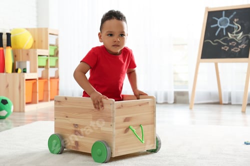 Preview: Cute little African-American child playing in kindergarten, space for text. Indoor activity