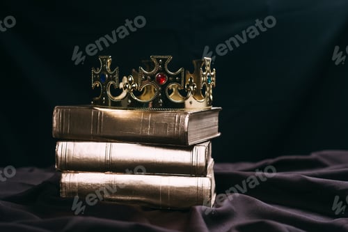 Preview: ancient golden crown with gemstones on books on black cloth