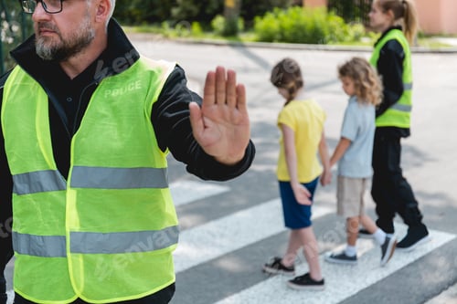 Preview: Policeman in a reflective vest raises his hand to stop the car before crossing the street