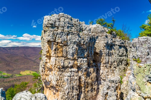 Preview: Rocky peak of a mountain with green trees on top of it in West Virginia
