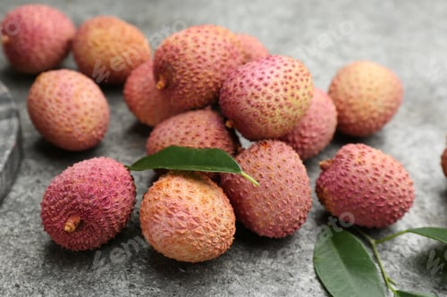 Preview: Fresh ripe lychee fruits on grey table, closeup