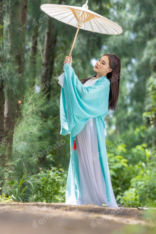 Preview: Young beautiful Asian woman dressed in ancient Chinese warrior style with ancient fan