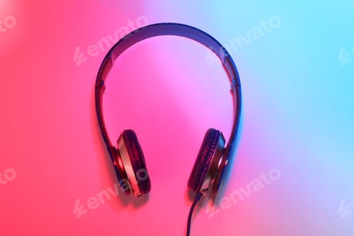 Preview: Stylish headphones on color background, top view