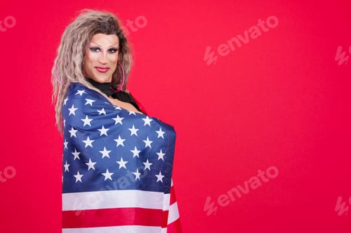 Preview: Transgender person looking at camera wrapping with an american flag