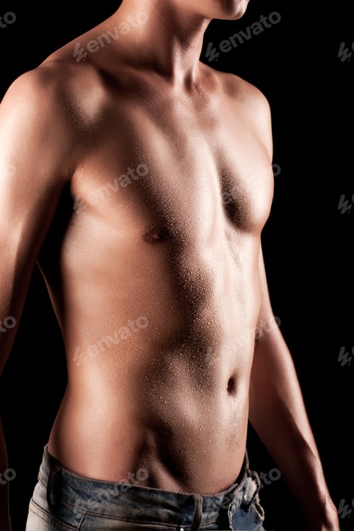 Preview: Young athletic man with naked torso in jeans standing over black background