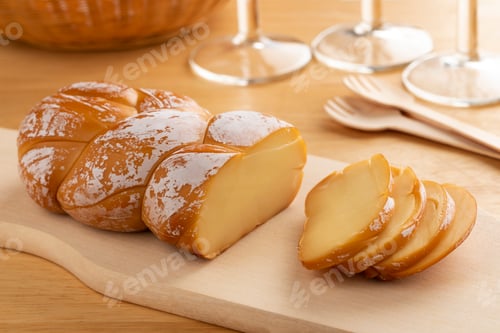 Preview: Traditional Romanian smoked cheese, Cascaval afumat,impletit,, on a cutting board