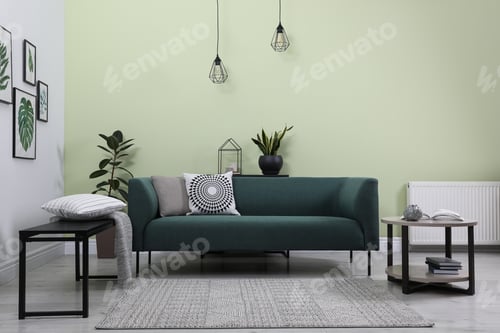 Preview: Stylish living room interior with comfortable green sofa and floral pictures