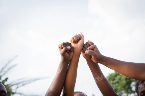 Preview: Four fists of African people united in sky, photo with copy space.