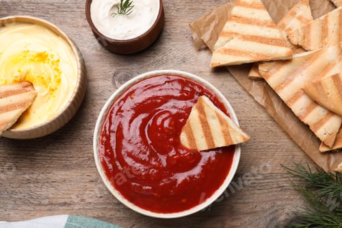 Preview: Sauce and pita chips on wooden table, flat lay