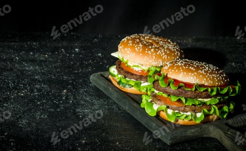 Preview: Burgers with beef, vegetables and salad on a stand.