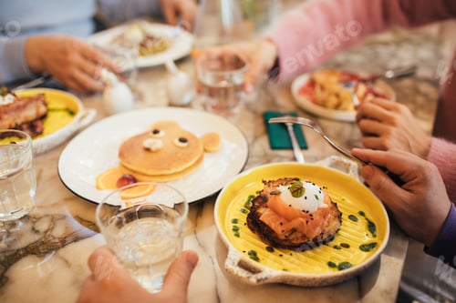 Preview: Group of millennial friends having breakfast together in a coffeeshop.