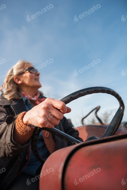 Preview: Senior female farmer driving tractor on international workers' day