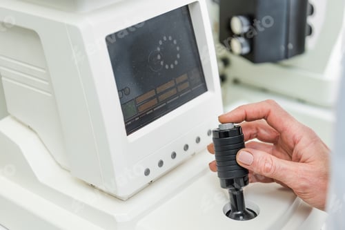 Preview: cropped view of optometrist working with slit lamp in clinic