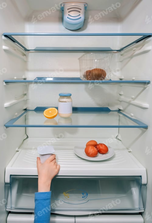 Preview: Girl hand taking the last yogurt from the fridge