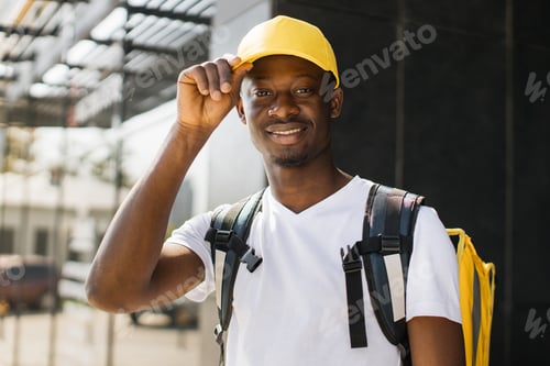 Preview: Food delivery, portrait of courier african man with yellow backpack and cap.