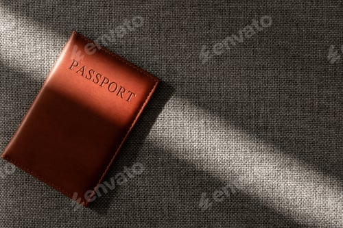 Preview: Brown leather passport cover on textured fabric in sunlight