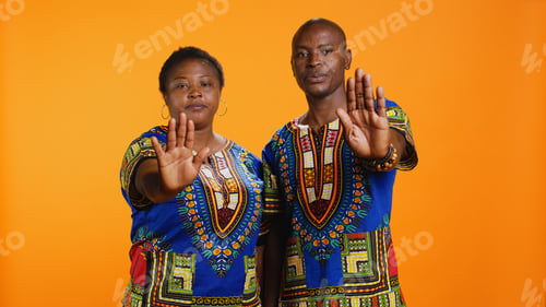 Preview: Confident ethnic couple showing stop sign in studio