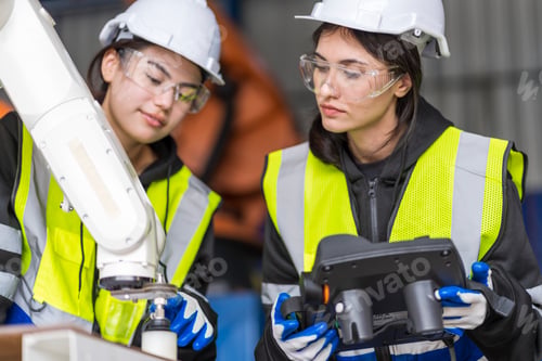 Preview: A team of female engineers meeting to inspect computer-controlled steel welding robots.