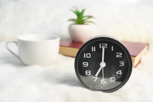 Preview: Black alarm clock and coffee cup with book on table