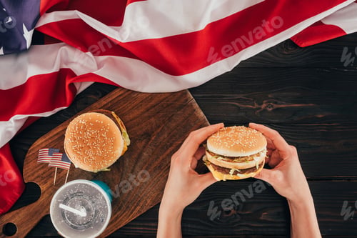 Preview: partial view of woman holding burger, presidents day celebration concept
