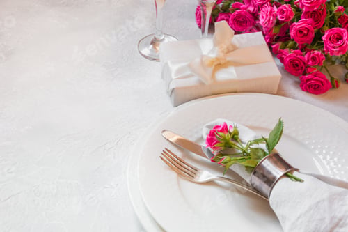 Preview: Romantic table setting with pink roses, silverware, and decorations. Top view.