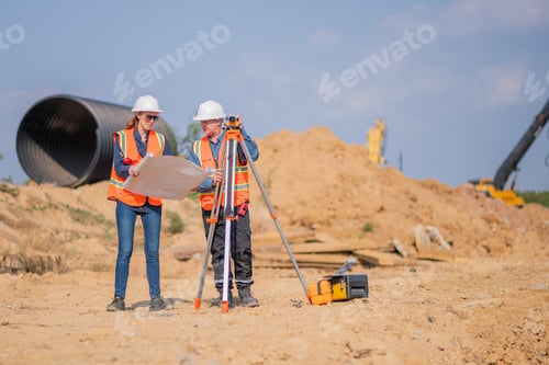 Preview: Construction surveyor or engineer working construction site blueprint and laptop for inspection deta
