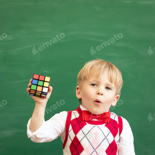 Preview: Child showing Rubik's Cube - 3D combination puzzle against green chalkboard