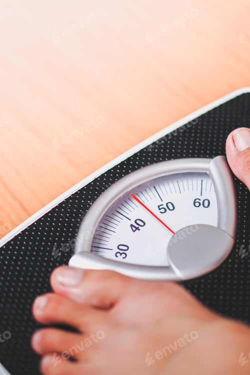 Preview: feet standing on a black scale weighing machine with a wooden base