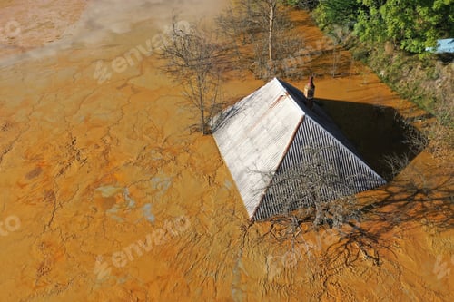 Preview: Aerial view of sinking village house in the middle of toxic mine decanting lake