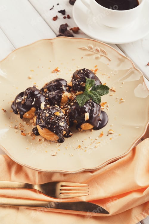 Preview: French profitroles with chocolate icing and mint leaves