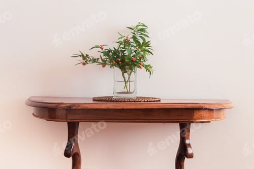 Preview: Bouquet of nightshade in a glass vase on a wooden old table against a white wall