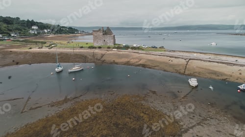 Preview: Brown sand beach of sea bay aerial. Flying bird at ocean shore. Old historic castle ruins