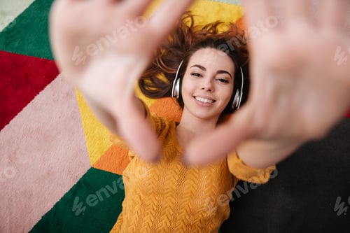 Preview: Portrait of a young smiling girl in headphones enjoying music