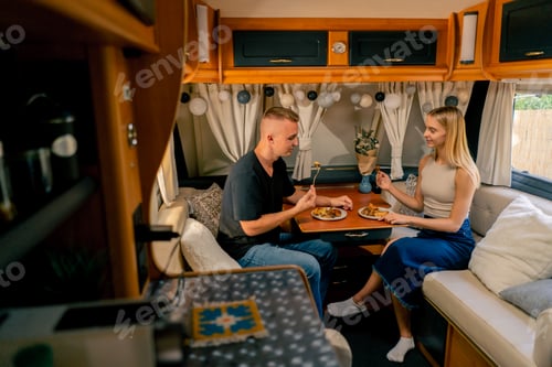 Preview: Couple in love together on a date in a mobile home sitting at the table and having dinner
