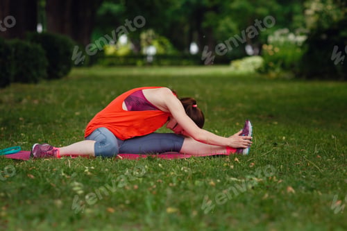Preview: Young fitness woman runner stretching legs before run