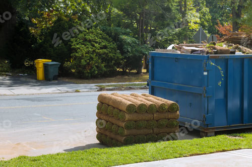 Preview: Installation of a modern landscape stacks of sod rolls for new lawn and dumpster full garbage