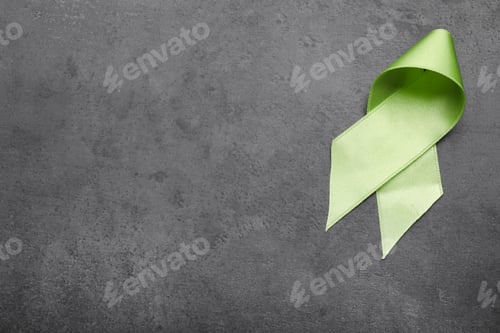 Preview: World Mental Health Day. Green ribbon on black background, top view with space for text