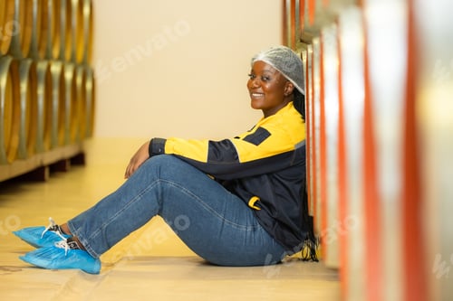 Preview: Young woman resting in wine cellar at winery