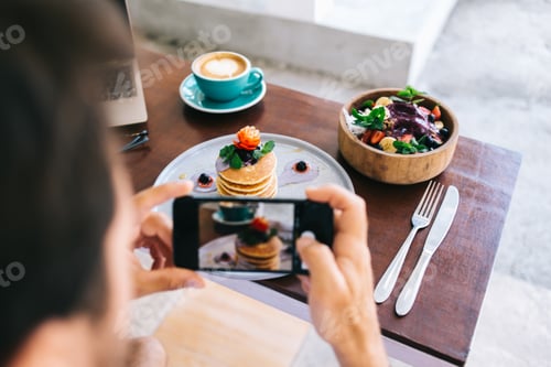 Preview: Anonymous man taking photo of breakfast set