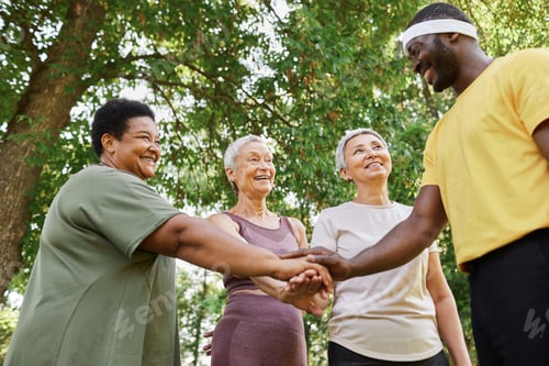 Preview: Group of active senior women stacking hands with trainer after outdoor workout