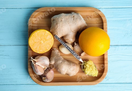 Preview: Fresh garlic and other natural cold remedies on light blue wooden table, top view