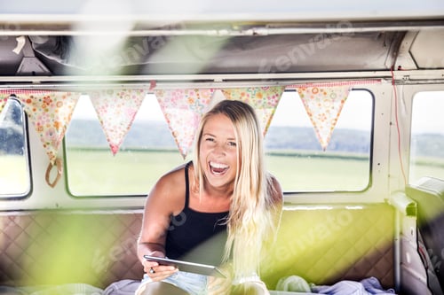 Preview: Carefree woman with tablet inside a van