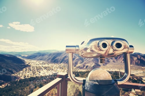 Preview: Color toned photo of binoculars looking out over a valley.